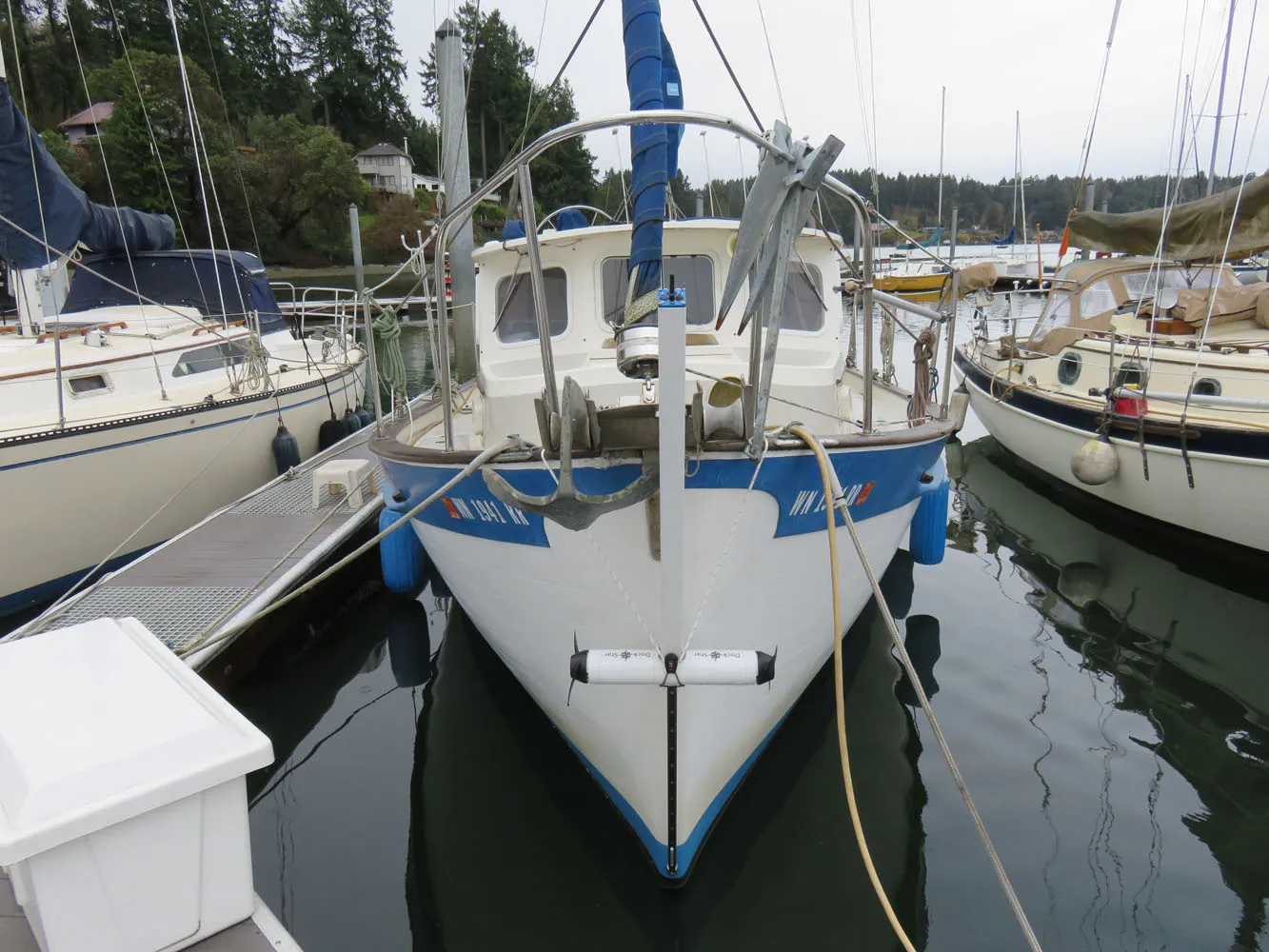 A DockStar on a track at the bow of a small trawler in a marina, pod raised.
