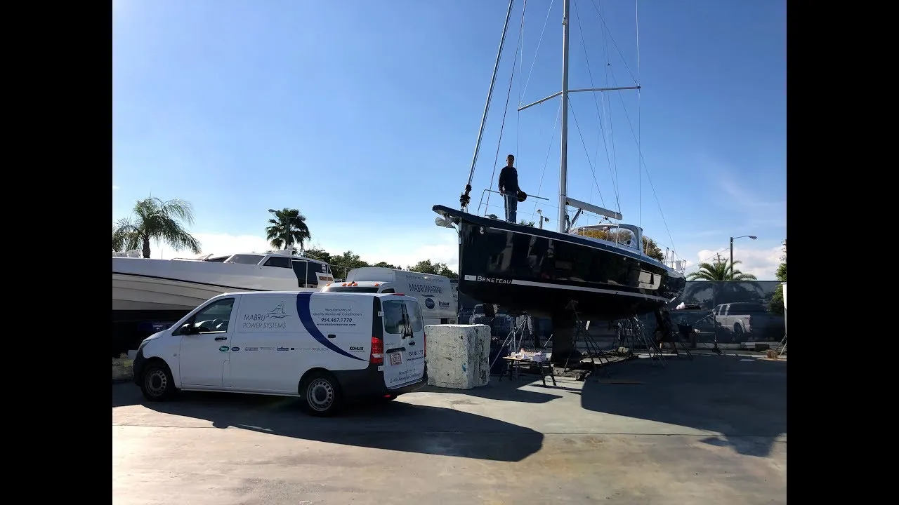 A still from Mabru: a sailboat on stands in a boatyard, a work van parked beside it.
