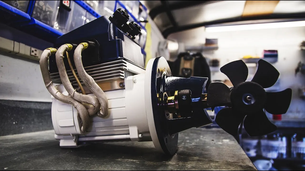 A still from Power and Motoryacht: a bow thruster motor and its black propeller on a workshop bench, cables coming off the top.
