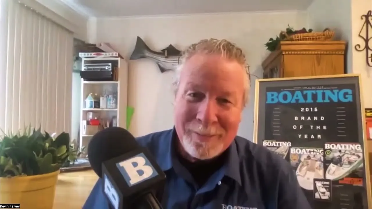 A still from Boating Magazine: a man with a Boating microphone in front of framed magazine covers.
