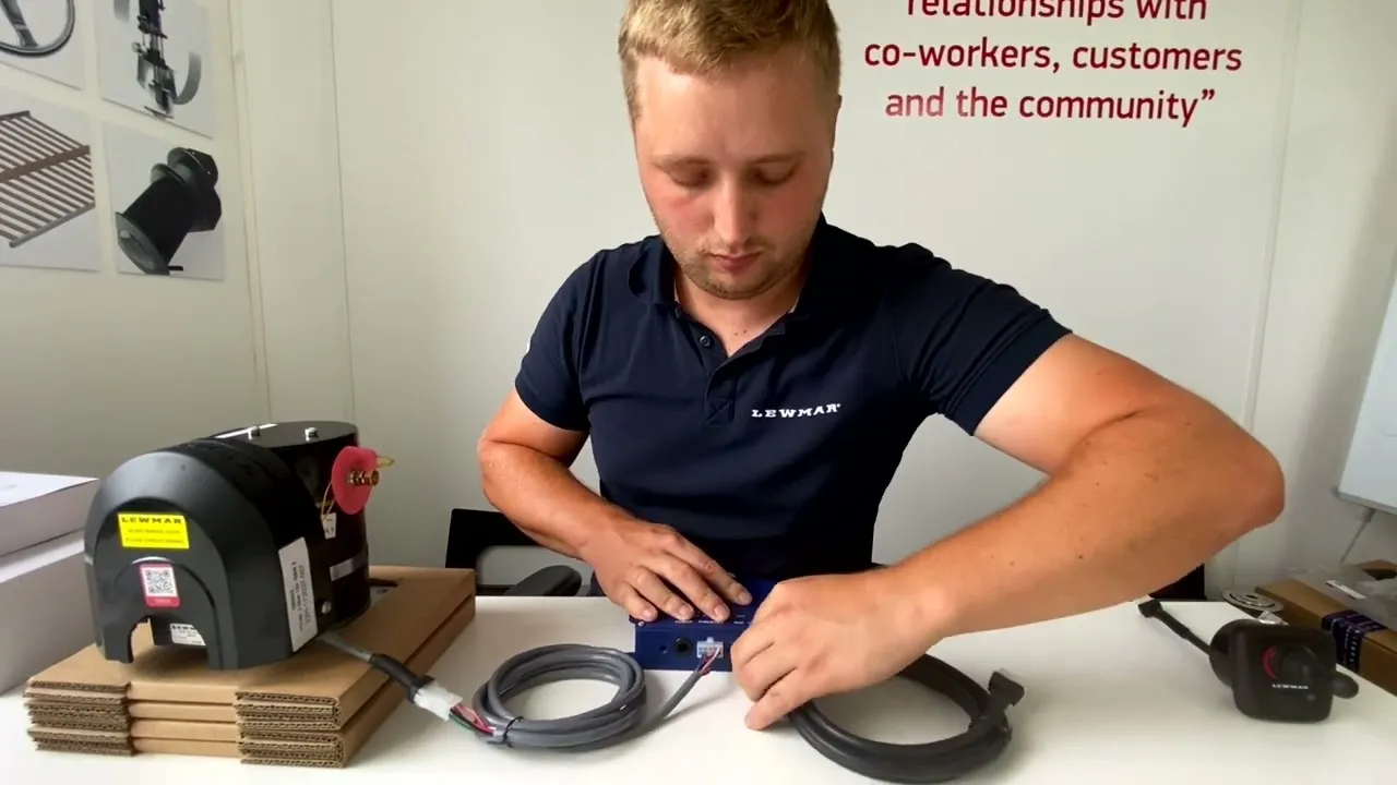 A still from Lewmar's video: a technician at a bench with a Gen 2 thruster motor, its control box and cables.