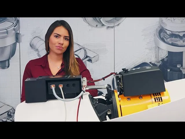 A still from VETUS's retractable video: a presenter at a bench beside a retractable thruster's motor and control box.