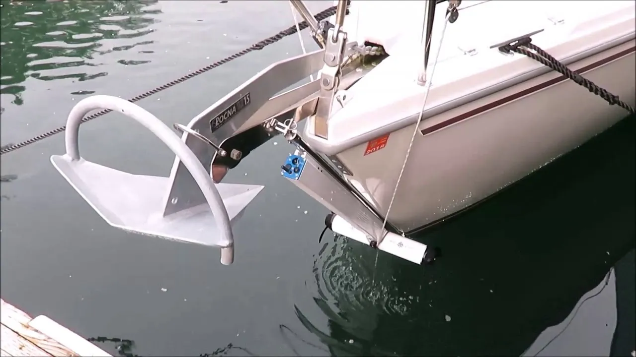 A still from DockStar's sailboat video: the bow of a white sailboat at a dock, the anchor on its roller, and the thruster on its track just below the waterline.