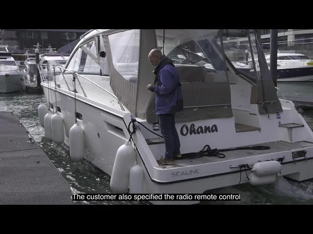 A still from Sleipner's external thruster video: an owner on the swim platform of a Sealine cruiser named Ohana, alongside a pontoon, remote in hand.